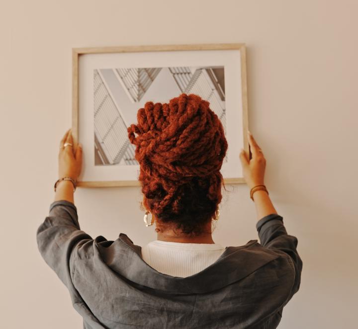 Woman putting a painting on the wall